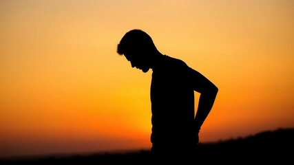 Silhouette of a male figure standing in profile against a sunset sky, figure, sunset, atmospheric