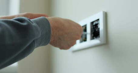 Electrician installing a wall socket. Installing electrical wall outlets with a screwdriver in a new home.