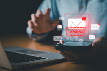 Business man using smartphone and computer that show warning sign after got attack phishing email...