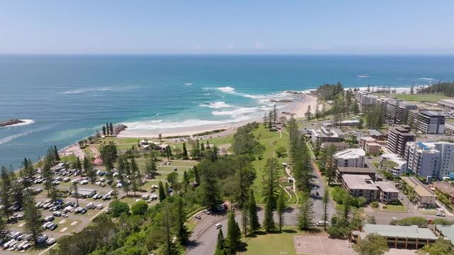 Aerial view of beautiful sandy beach and vibrant urban buildings surrounded by lush green park and trees, Fraser Island, Australia.