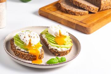 Two avocado open sandwiches with egg. Keto and diet concept. Healthy toast food for breakfast.