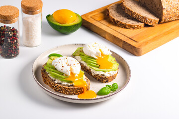 Two avocado open sandwiches with egg. Keto and diet concept. Healthy toast food for breakfast.