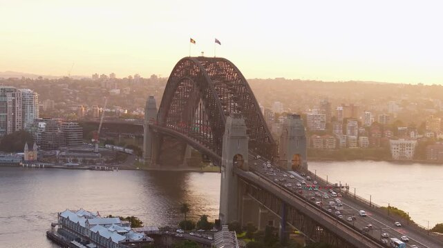 Aerial view of beautiful Sydney Harbour Bridge at sunset with a bustling cityscape and river, Sydney, Australia.