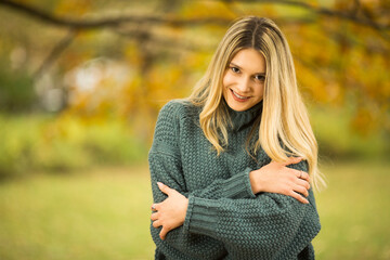 Portrait of beautiful blonde young woman in green sweater