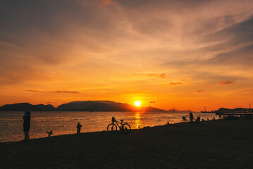 Silhouettes of people against the background of dawn on the beach in Nha Trang, Vietnam.
