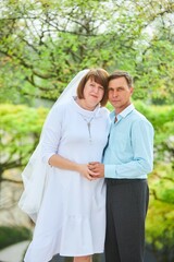 Obraz premium An adult bride and groom . Husband and wife's wedding anniversary photo shoot. We've been together for 30 years.
