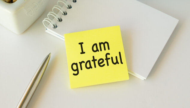 Note paper on white background with handwritten text I AM GRATEFUL - concept of gratitude , means being thankful or show appreciation for good things or kindness in life