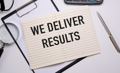 WE DELIVER RESULTS text on notebook with pen on a chart background.