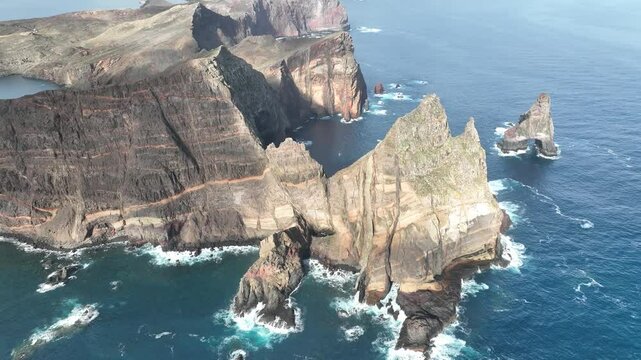Aerial view of dramatic cliffs and azure ocean with rugged rock formations, Dorgali, Italy.