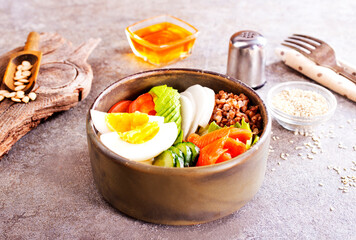 Healthy vegan nutritious bowl with buckwheat. Salad of avocado, salmon, buckwheat, egg and tomato, top view
