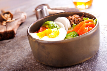 Healthy vegan nutritious bowl with buckwheat. Salad of avocado, salmon, buckwheat, egg and tomato, top view