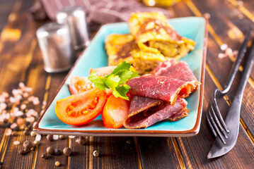 omelet with smoked meat, tomato and spice