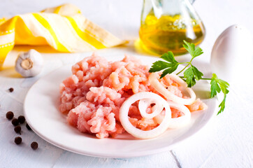 Minced Meat with herbs and onion on wooden table