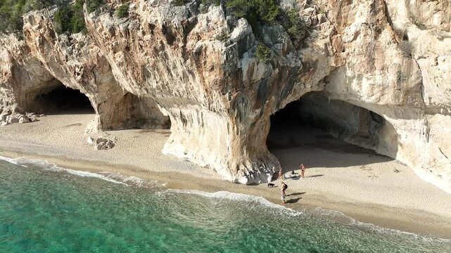 Aerial view of the beautiful grotto and idyllic beach with turquoise water and scenic cliffs, Dorgali, Italy.
