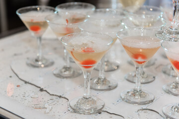 Glasses with champagne and cherries. Festive alcohol on the table.