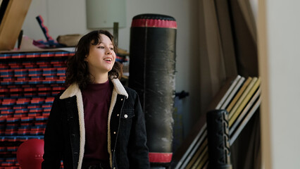 A girl with her hand on her hip reacts expressively, surrounded by gym and training equipment. This image reflects themes of character, determination, and an active mindset.