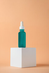 Blue glass cosmetic bottle, Skin care or sunscreen cosmetic with stylish props on cream background.