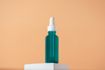 Blue glass cosmetic bottle, Skin care or sunscreen cosmetic with stylish props on cream background.