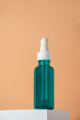 Blue glass cosmetic bottle, Skin care or sunscreen cosmetic with stylish props on cream background.