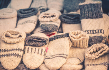 Cozy handmade woolen socks in beige and gray tones, neatly displayed for sale. Warm winter accessories perfect for cold weather, showcasing traditional craftsmanship and natural fibers