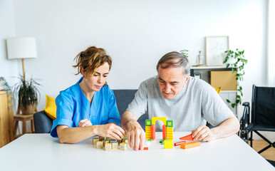 Professional nurse caregiver in geriatric clinic helps senior man with Alzheimer's disease - Old...