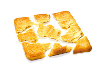 Cracker pieces isolated. Crumbled square biscuits. Sugar coated biscuits on white background