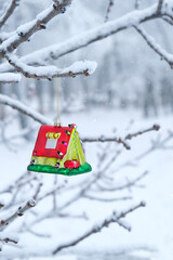 Festive winter background. christmas toy of tourist tent hang on snowy tree branch. Christmas, new year holidays. Christmas greeting card design for during hiking, travel, tourism, mountaineering