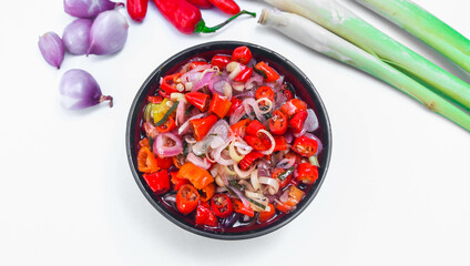 Indonesian Balinese sambal matah served in a bowl isolated on a white background. a type of chili sauce made from raw spices such as chilies, lemongrass, onions, lime leaves.