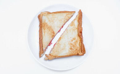 close up of white toast bread with strawberry jam on a plate, two sliced ​​bread isolated on white background. Toast bread