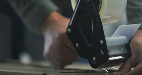 Hands, tape gun and packing box with closing package for property relocation, real estate and moving. Closeup, woman and tool with cardboard, parcel and seal for product safety and delivery in house