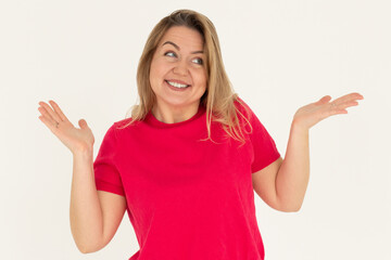 Fototapeta premium Confused thoughtful smiling young woman holding copy space on palm over white background
