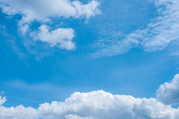 Fluffy, bright clouds and blue summer sky background.