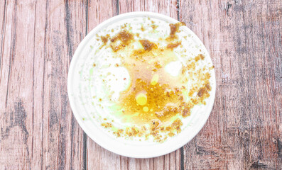 Empty Dirty Plate after Eating. Remaining Oil Stain and Smeared Sauce on White Plate Background Top View