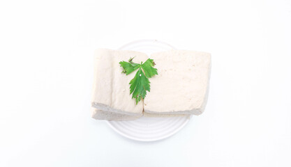 Fresh white tofu cubes on a white plate isolated white background. Fresh soybean tofu.