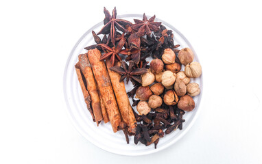 Group of cardamom, cinnamon, star anise, anise seed, clove, coriander seeds, isolated on white background. Gather natural spices in one plate
