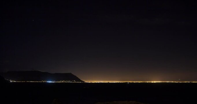 A wide, evening Time Lapse over Flase Bay Harbor, moving clouds and the yellow glow of surrounding lights