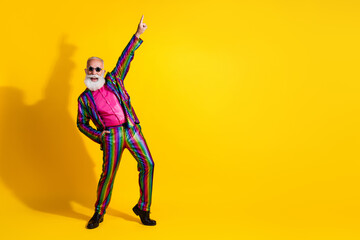 Photo of crazy charismatic man wear stylish striped bright suit dance night club theme party isolated on yellow color background