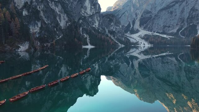 Wooden boats floating on the still, reflective waters of Braies Lake surrounded by alpine mountains