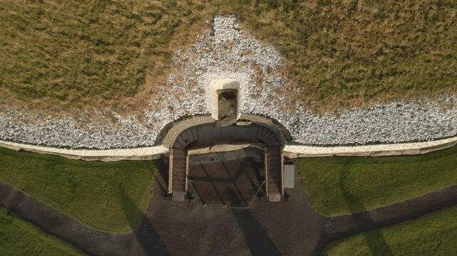 Newgrange monument in Ireland glows with golden sunlight at sunrise above the River Boyne