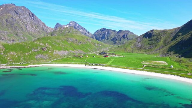 Aerial view of pristine Haukland beach and tranquil bay surrounded by majestic mountains, Leknes, Norway.