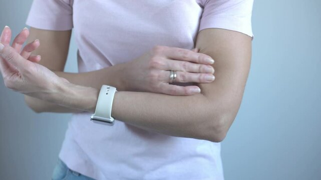 Female trainer shows how to relieve tension in the biceps of the arm. Hand massage.