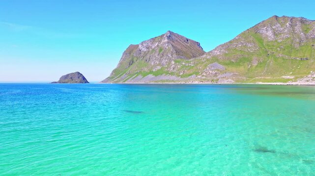 Aerial view of pristine Haukland beach and turquoise water bay surrounded by majestic mountains, Leknes, Norway.