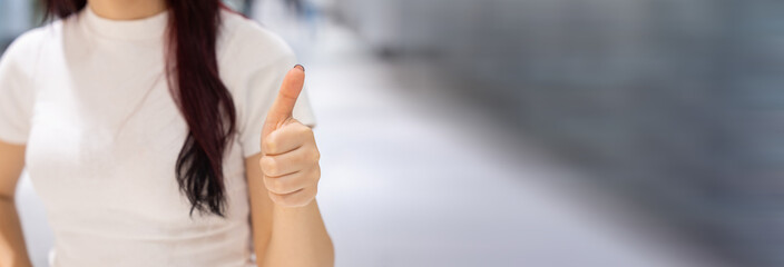 The girl held her thumb up with her hands, a positive sign