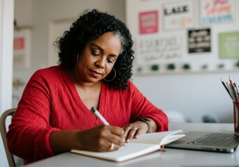 Concentrated mature businesswoman taking notes in notebook while working remotely at home office