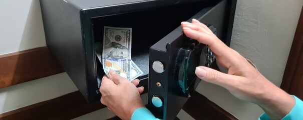 Hand opens and closes safe hidden in closet in hotel