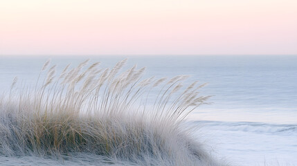 Serene coastal scene with tall grasses gently swaying in the breeze against a soft pastel sky and calm ocean. Peaceful, minimalist aesthetic.