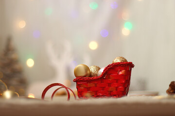 Various Christmas decorations, lit candles, cup of tea or coffee, cookies, books, presents and soft blanket on the table. Holiday hygge at home. Selective focus.