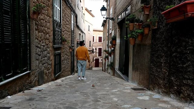 A man walking down a street in Estellencs