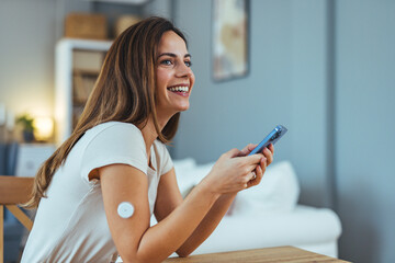 Smiling Woman Using Phone with Glucose Monitoring Device