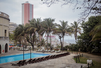 Obraz premium Tranquil poolside view in Havana, Cuba featuring palm trees and city skyline